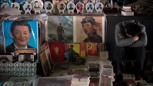 Un vendedor echa una siesta junto a los carteles de Mao Zedong y Xi Jinping el pasado 15 de mayo. día en que se cumplían 50 años de la Revolución Cultural china