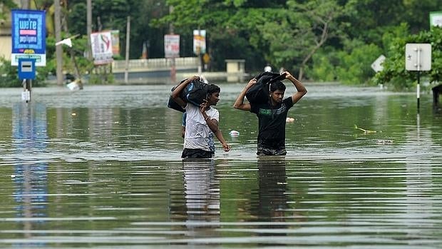 Dos jóvenes caminan por las calle inundadas de Biyagama, a 17 kilómetros de la capital de Sri Lanka, Colombo