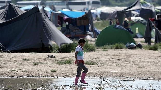 Un niño anda por el barro en el campo de Idomeni