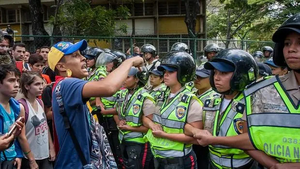 Estudiantes gritan consignas frente a miembros de la Policía Nacional Bolivariana (PNB), durante una manifestación este jueves, contra la crisis en las universidades públicas venezolanas