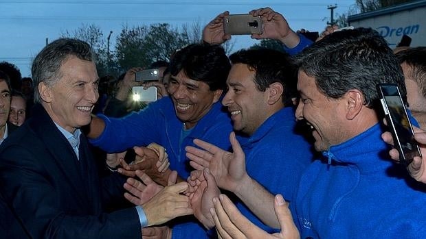 Fotografía cedida por la Presidencia de Argentina que muestra al presidente argentino, Mauricio Macri (i), mientras saluda a empleados de una fábrica de electrodomésticos