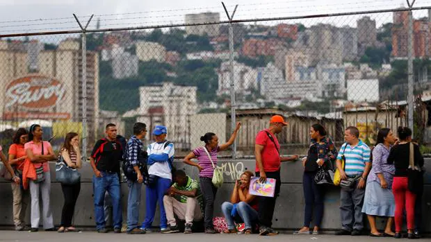 Venezolanos hacen cola para comprar en un supermercado de Carcacas este lunes