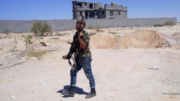 Un soldado de las tropas de la alianza formada por el gobierno de unidad vigila la rotonda de Al Zafran, un cruce de caminos estratégico