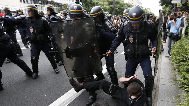 Un manifestante es detenido por efectivos de la policía antidisturbios, durante una nueva protesta convocada contra la reforma laboral del Gobierno