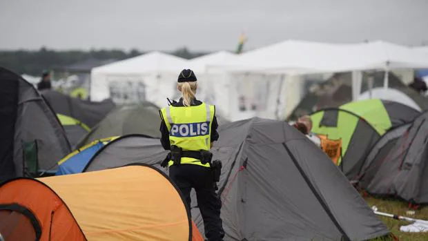 Una agente de policía permanece en guardia en la zona de acampada del festival de Bravalla en Suecia