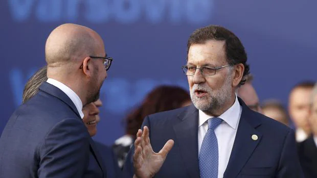 El presidente de Gobierno en funciones, Mariano Rajoy, habla con el primer ministro belga, Charles Michel, durante la cumbre de la OTAN en Varsovia