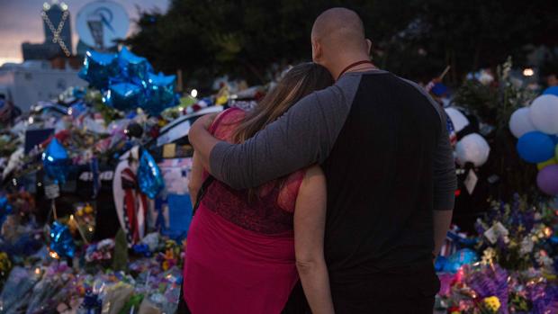 Una pareja se abraza ante el homenaje a los agentes caídos en la matanza de Dallas a las afueras del departamento de policía