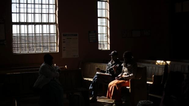 Unos trabajadores electorales descansan en una iglesia, convertida en un colegio electoral, mientras ultiman los preparativos para las elecciones municipales de 2016 en Alexandra, Johannesburgo