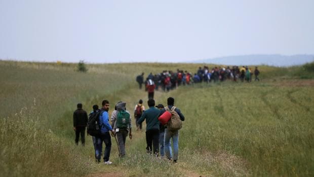 Un grupo de refugiados salen del campo de Idomeni para cruzar la fronter que separa a Grecia de Macedonia