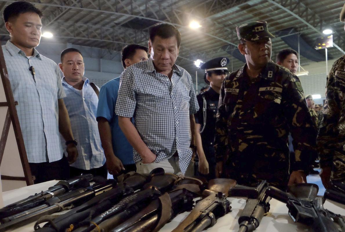 Duterte examina ayer, 9 de agosto, varias de las armas confiscadas por la policía militar