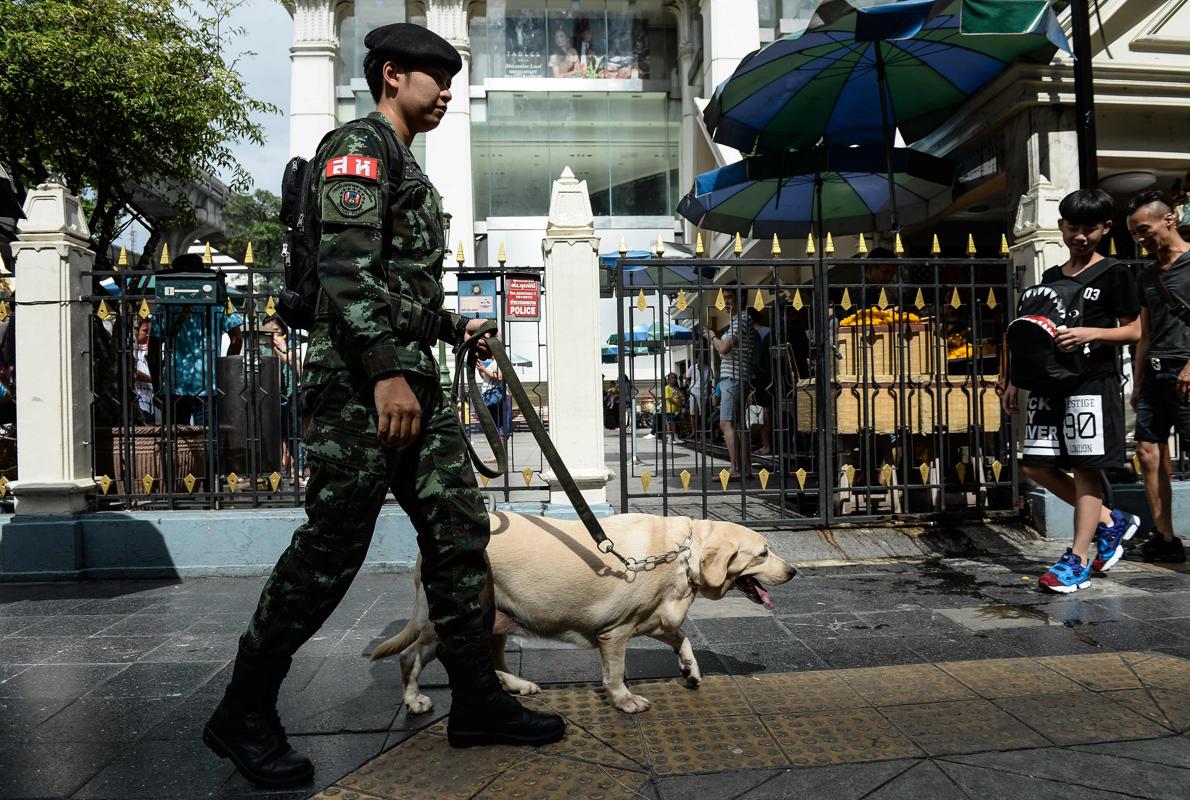 Un soldado tailandés patrulla con un perro policía la localidad de Eraway Shrine, un popular destino turístico atacado el año pasado