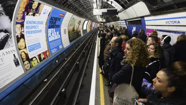 Decenas de personas esperan en un andén en la estación de metro Victoria en Londres