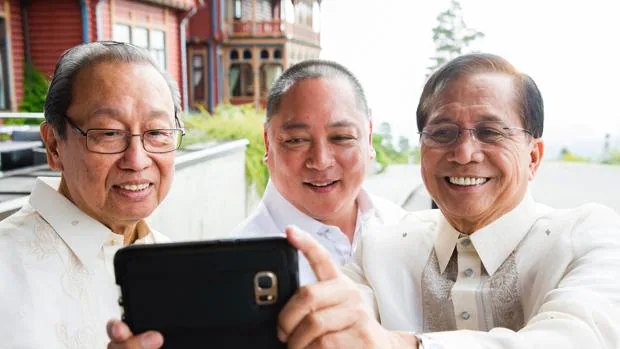 El exiliado líder del Partido Comunista de Filipina, Jose Maria Sison, se hace un selfie con Joey Fornier, miembro del Gobierno, y Jesus Dureza, consejero de paz, este lunes en Oslo