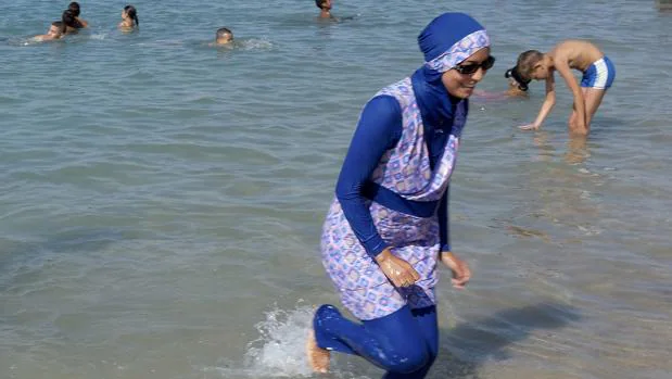 Una mujer se baña ataviada con un burkini en una playa de Marsella