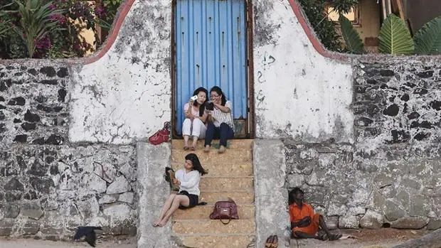Una mujer con falda se sienta en unas escaleras en la India