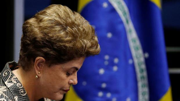 La presidenta sustituida de Brasil, Dilma Rousseff, junto a la bandera de su país