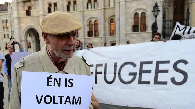 Un hombre sostiene un cartel que reza: «Yo también fui refugiado» en Hungría