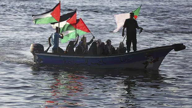 Varias mujeres palestinas ondean su bandera nacional en solidaridad con la coalición Flotilla de la Libertad cerca del puerto de Gaza