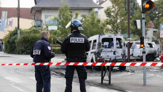 Vehículo polícial y furgoneta incendiados por cócteles Molotov lanzados por una quincena de individuos, este sábado en Viry-Chatillon, cerca de París