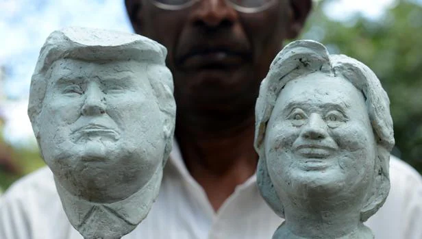El artista de Sri Lanka Upali Dias posa con dos bustos de los candidatos americanos de su autoría