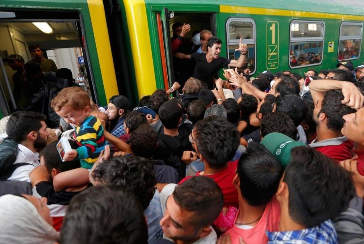 Refugiados en la estación de Budapest intentan subir a un tren para llegar a Austria