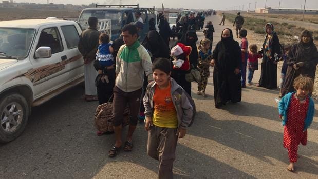 Interminable caravana de vehículos que llegan de la localidad de Topzawa, en el extrarradio de Mosul.