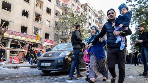 Una familia huye de la zona afectada por un atentado con coche bomba este viernes en Diyarbakir, la «capital» kurda de Turquía