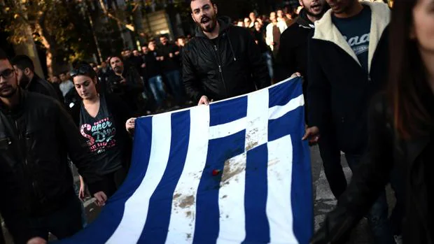 Varios estudiantes lideran la marcha de este jueves con la bandera griega manchada de sangre, símbolo de la revuelta que se produjo en el país heleno en 1973