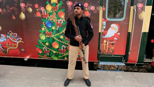 Un policía está de guardia cerca del tren de la paz de Navidad durante una ceremonia antes de las celebraciones de Navidad en Islamabad