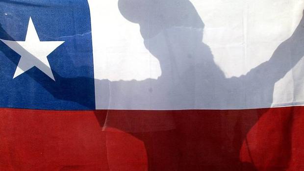 Una mujer sostiene una bandera de Chile