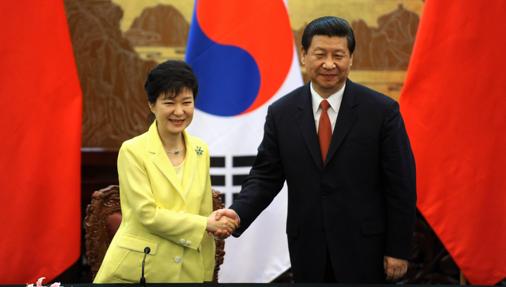 Park Geun-Hye (i), suspendida de sus funciones como presidenta de Corea del Sur, saluda al presidente chino, Xi Jinping, durante un acto oficial en Pekín en 2013