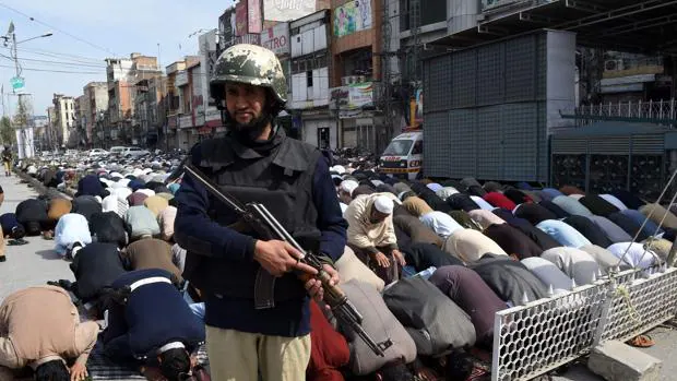 Un policía paquistaní vigila en Peshawar (Pakistán) durante la oración en la calle