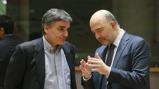 El comisario europeo de Asuntos Económicos y Monetarios, Pierre Moscovici (d), conversa con el ministro griego de Finanzas, Euclides Tsakalotos
