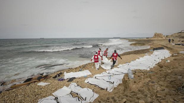 Miembros de la Cruz Roja recogen los cadáveres de al menos 74 personas tras un naufragio frente a las costas de Libia