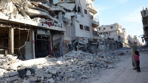 Un hombre toma fotos de las casas destruidas en Al Bab