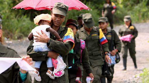 Mujeres de la guerrilla de las Fuerzas Armadas Revolucionarias de Colombia (FARC) marchan con sus hijos desde su campamento transitorio hacía una zona veredal