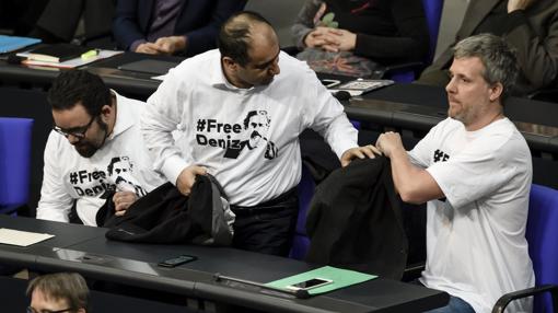 El diputado del partido Los Verdes Oezcan Mutlu (c) junto a dos compañeros muestra una camiseta en solidaridad con el periodista germanoturco Deniz Yucel