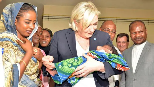 Marine Le Pen (c), con un bebé en brazos, en un hospital infantil de N'Djamena, durante su visita esta semana a las tropas francesas desplegadas en Chad para combatir el yihadismo
