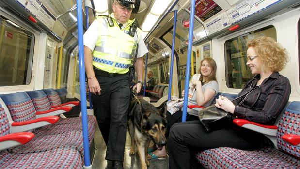 Un oficial de policía de transporte británico y su perro patrulla supervisan un vagón del metro de Londres tras su reapertura en agosto de 2005, días después del atentado de Al Qaida en la capital inglesa