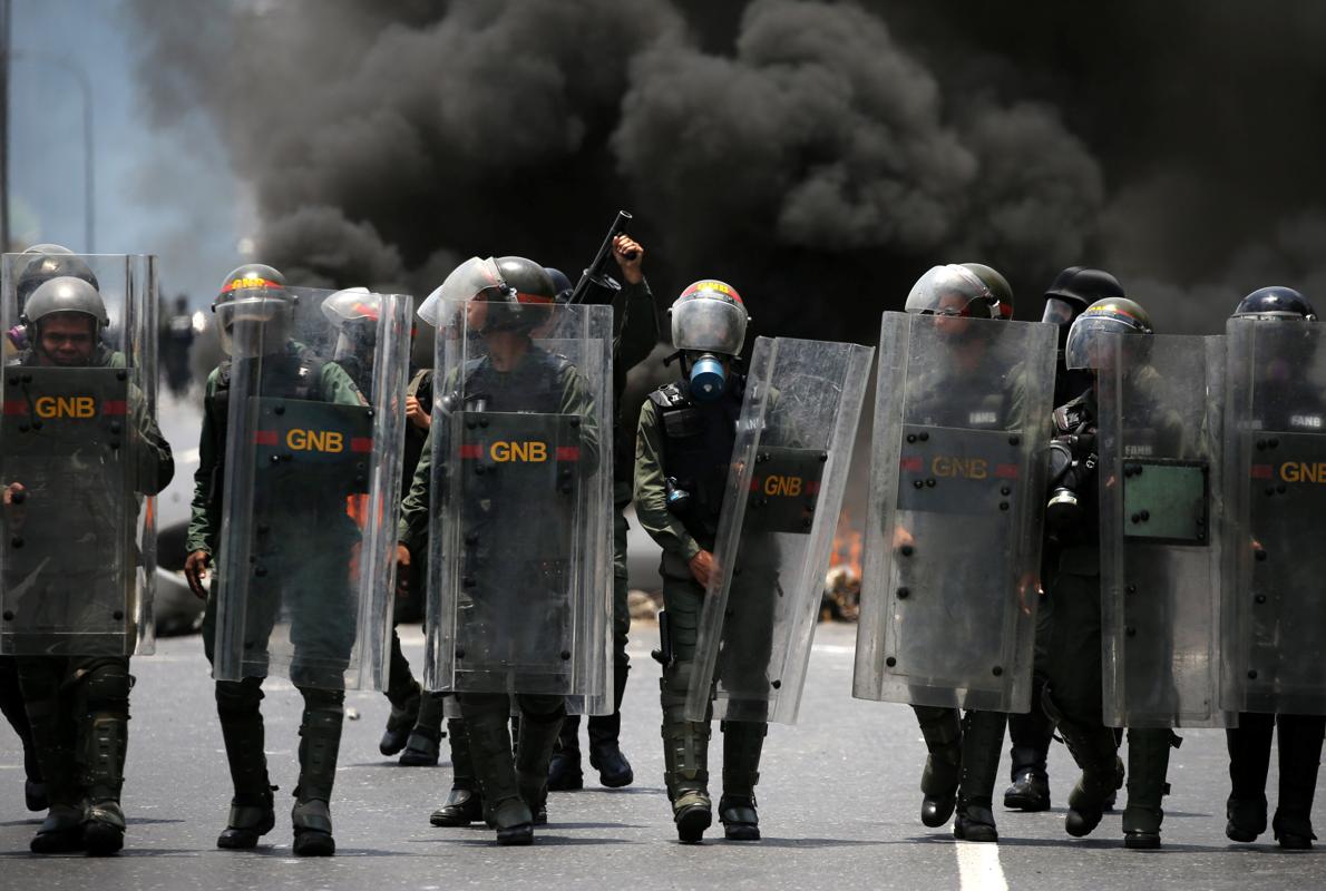 Miembros de la Guardia Nacional Bolivariana se sitúan para repeler a los manifestantes