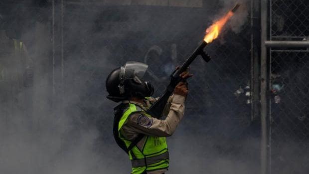 Un agente de la Guardia Nacional Bolivariana bloquea una marcha opositora con gases lacrimógenos, el pasado jueves en Caracas