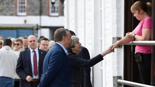 Theresa May saluda a una mujer durante una visita preelectoral a Mevagissey (suroeste de Inglaterra)