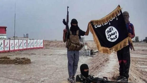 Imagen de yihadista, en algún lugar de Siria, sosteniendo la bandera de Daesh