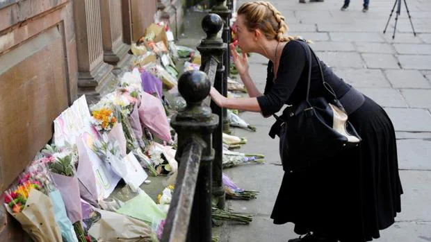 Una mujer lanza un beso tras depositar unas flores en un memorial por las víctimas del atentado de Mánchester