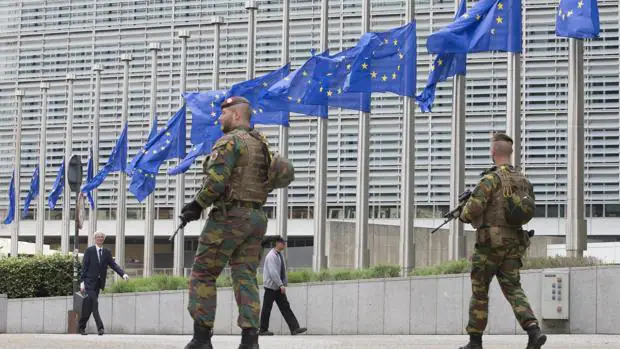 Soldados belgan patrullan junto a las banderas de la Unión Europea