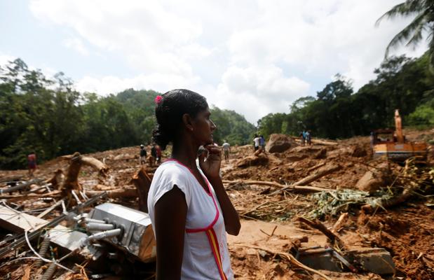  Una mujer reacciona al ver el lugar donde se encontraba su casa, sacudido por un deslizamiento de tierra en el pueblo de Athwelthota