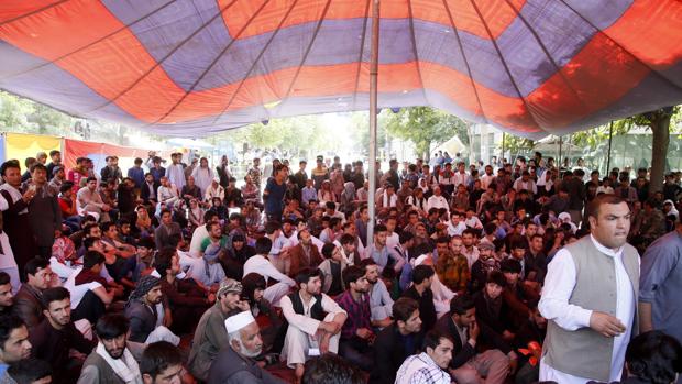 Un grupo de manifestantes afganos se sientan en un campamento cerca del palacio presidencial afgano mientras exigen la renuncia de funcionarios de seguridad en Kabul (Afganistán)