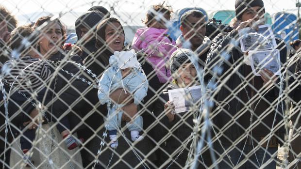 Un grupo de refugiados aguarda en la frontera entre Grecia y Macedonia