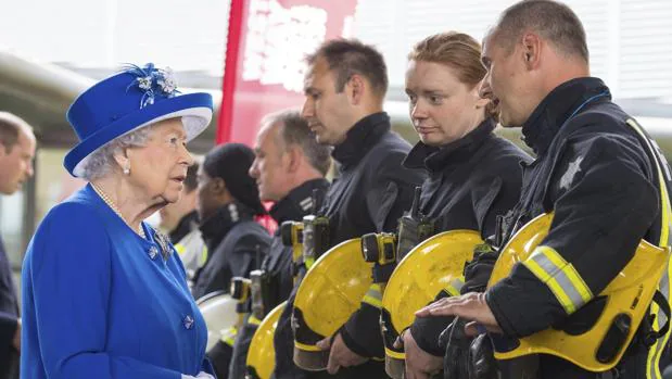 La reina Isabel II conversa con bomberos durante una reunión con residentes de la torre Grenfell en Londres (Reino Unido) hoy, 16 de junio de 2017