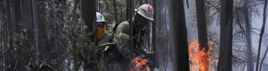 Dos miembros de la Guardia Nacional Republicana (GNR) portuguesa combaten el fuego en Alto da Louriceira